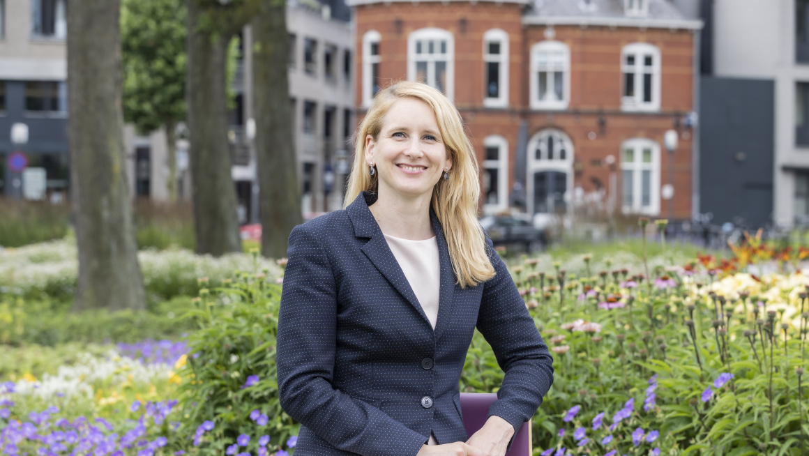 vrouw zit op bankje in park, paarse bloemen om haar heen