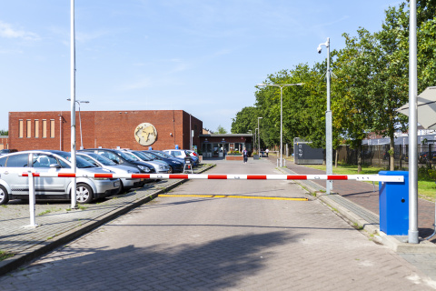 Slagboom bij de ingang van Ter Apel met op de achtergrond het receptiegebouw