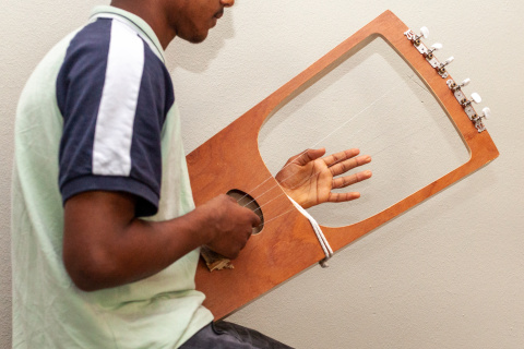 jongen speelt soort van harp